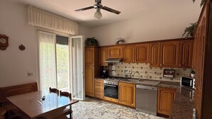 A kitchen with wooden cabinets, a dining table, and a ceiling fan.