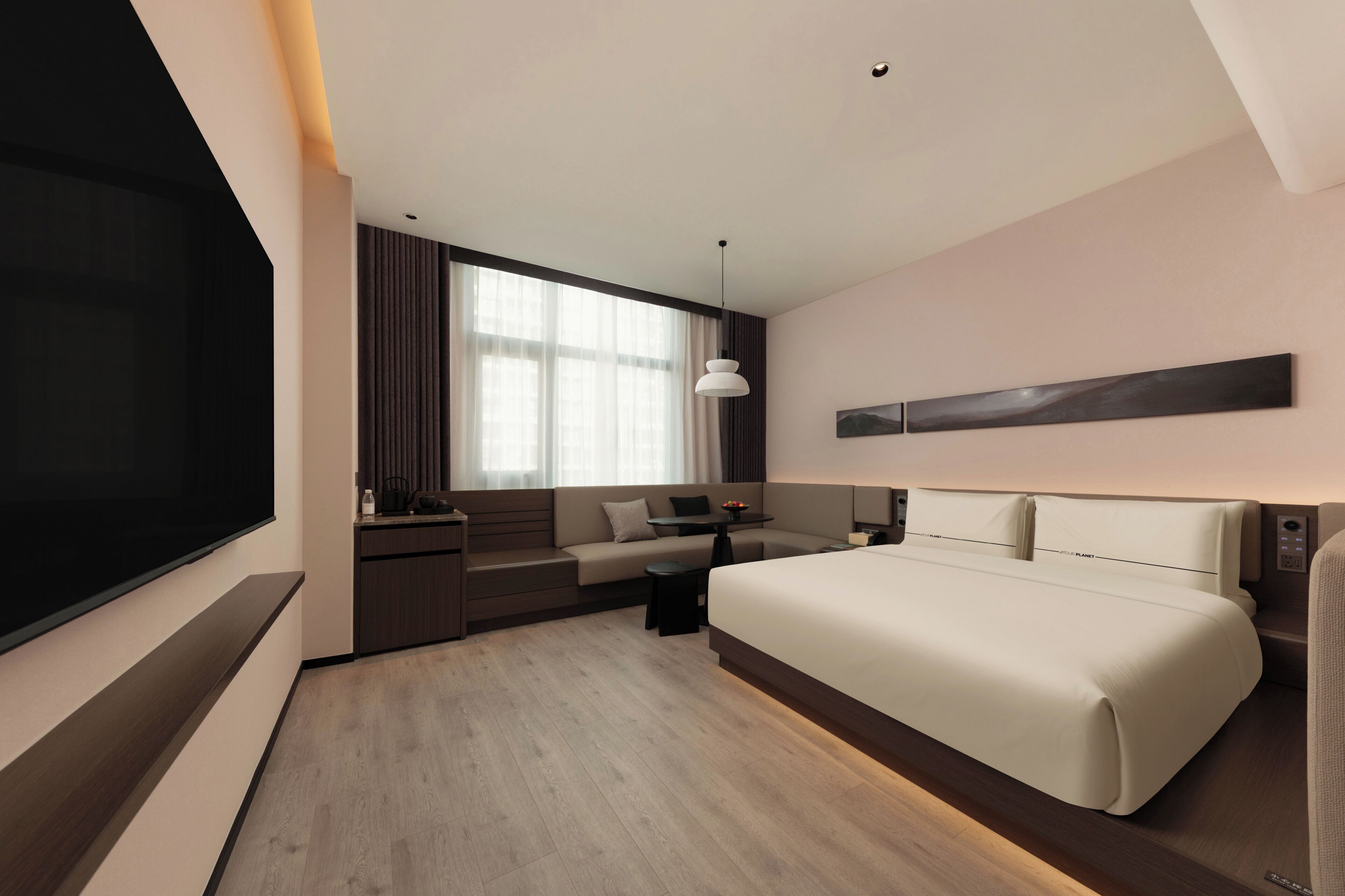 A modern hotel room with a large bed, a flat-screen TV, a desk with a chair, and a large window with curtains.