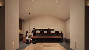 A reception area with a curved ceiling, a reception desk, a seating area, and a potted plant. - Atour Hotel Nanjing Jianye (Nanjing)