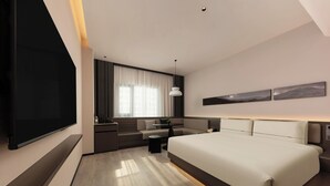 A modern hotel room with a large bed, a desk, a sofa, and a TV. - Atour Hotel Nanjing Jianye (Nanjing)