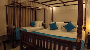 Cama con dosel y cuatro columnas con dos camas separadas, muebles de madera y un banco.