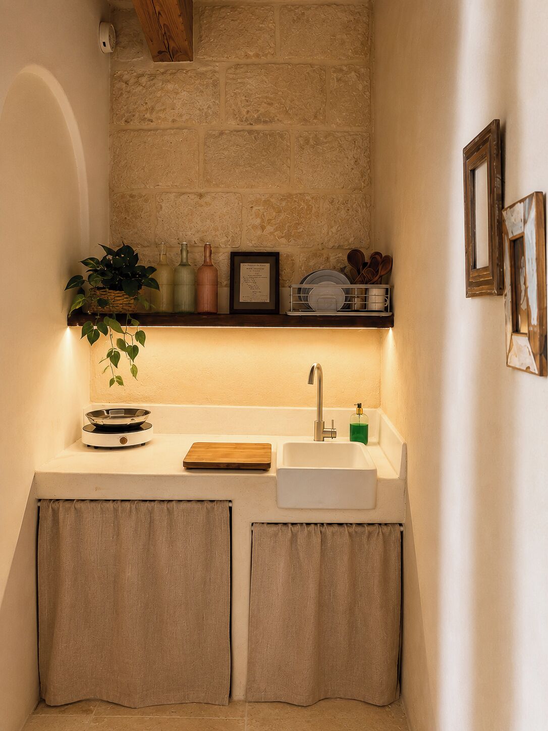 A compact kitchen with a stone backsplash, a white sink, and a small countertop.