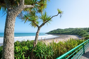 A coastal landscape with a beach, a tree, and a railing. - 2 Bed in Langland (oc-hh142) (Newton)