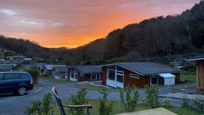 Ett bostadsområde med hus, en parkerad bil och en solnedgång.
