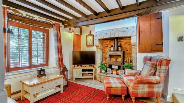 A cozy living room with a fireplace, a television, and plaid furniture. - 2 Bed in Pickering (oc-y114) (Pickering)