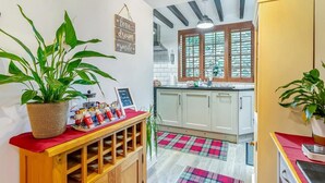 A kitchen with wooden cabinets, a red countertop, a window with blinds, and a checkered floor mat. - 2 Bed in Pickering (oc-y114) (Pickering)