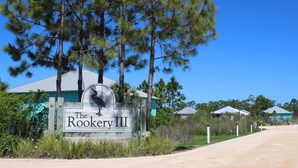 Puinen kyltti, jossa lukee ”The Rookery III”, ja sen ympärillä on mäntyjä sekä soratie.