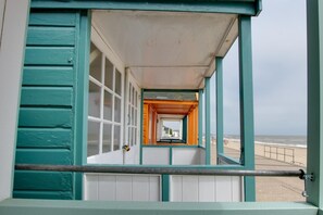 Ein Korridor mit Blick auf den Strand, ausgestattet mit Geländer und einer Tür.