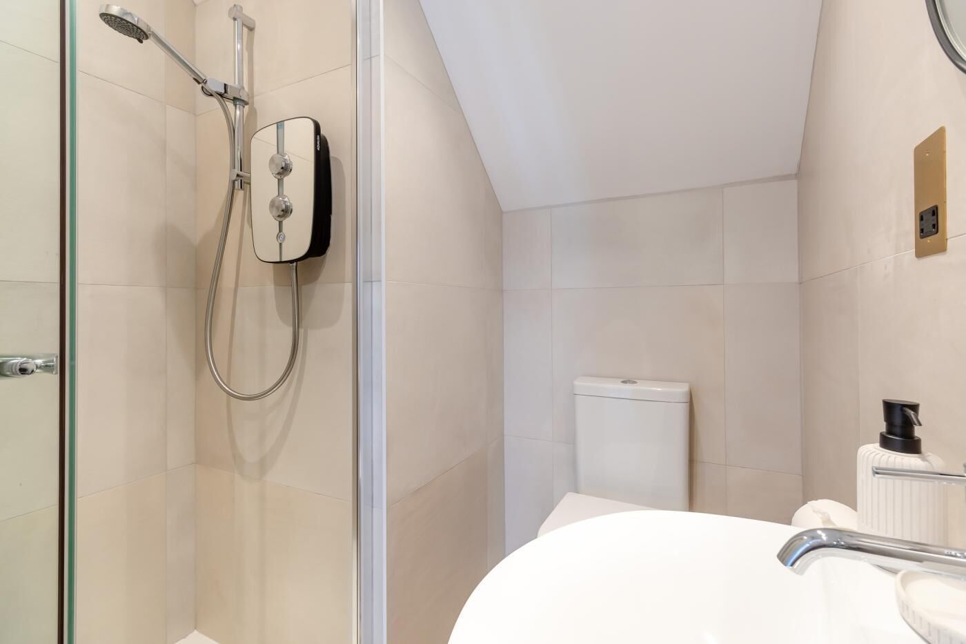 A modern bathroom with a glass shower enclosure, a white toilet, and a sink with a faucet.