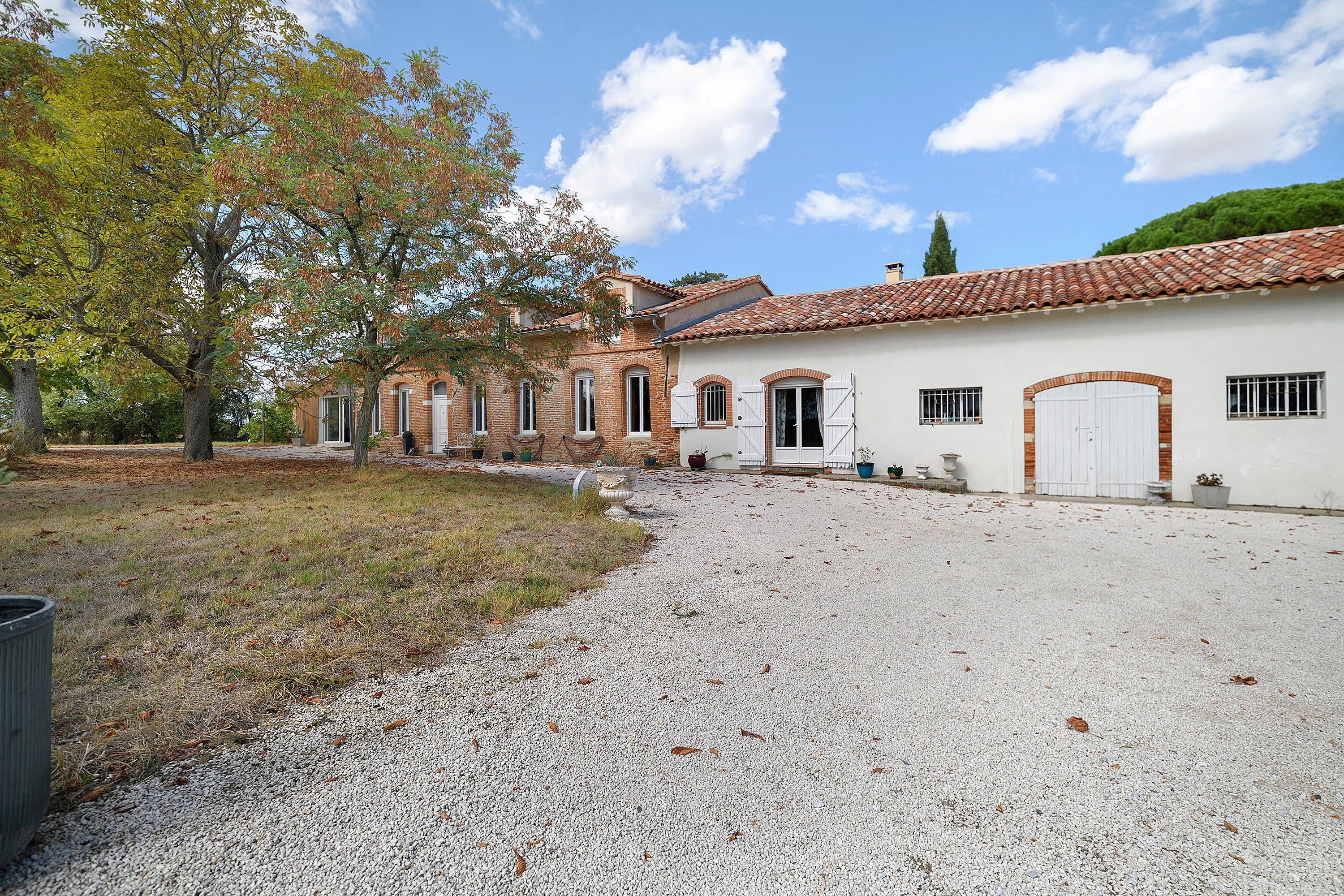 A building with a gravel driveway and a tree-lined path.