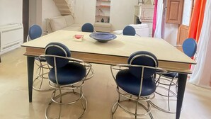 Ein Essbereich mit hoher, gewölbter Decke, einer Treppe und Blick zum Himmel.