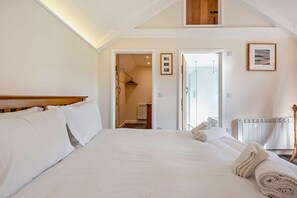 Ein Schlafzimmer mit einem großen Bett, einem hölzernen Kopfteil, einem Heizkörper und einem gerahmten Bild an der Wand.