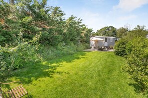 A house with a covered porch, surrounded by a well-maintained lawn and dense shrubbery. - 1 Bed in St. Dominick (oc-h28184) (Saint Dominick)