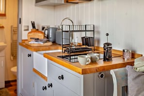 A compact kitchen with a wooden countertop, a coffee maker, and a kettle. - 1 Bed in St. Dominick (oc-h28184) (Saint Dominick)