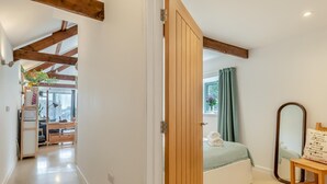 Une chambre à coucher avec un lit, un miroir et une fenêtre avec des rideaux.