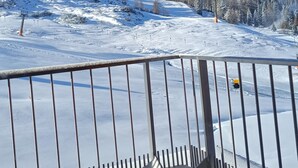 Un paysage enneigé, avec une balustrade en bois et un ciel d’un bleu limpide.