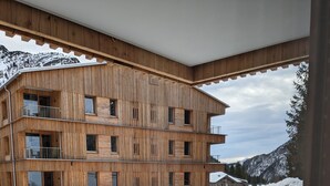 Un edificio de madera de varios pisos con balcones, paisaje nevado y cielo despejado.
