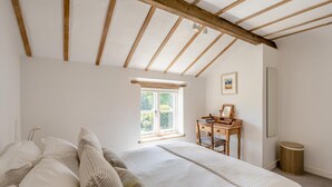 A bedroom with a large bed, a desk, a chair, a window, and a mirror. - 3 Bed in Orford (oc-t32016) (Orford)