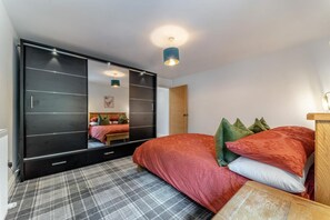 A bedroom with a bed, a large mirror, a wardrobe, and a plaid carpet. - 3 Bed in Innellan (oc-c32370) (Innellan)