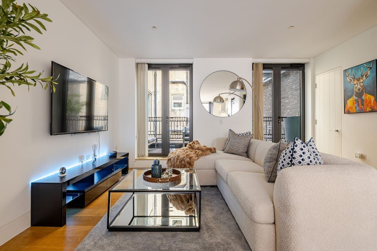 A modern living room with a sofa, coffee table, and television.