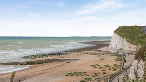 A coastal landscape with a beach, rocky shoreline, and a cliff. - 4 Bed in Saltdean (oc-a32366) (Saltdean)