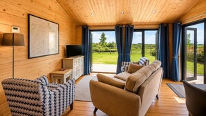 Et trægulv med sofa, fjernsyn og et kort på væggen.