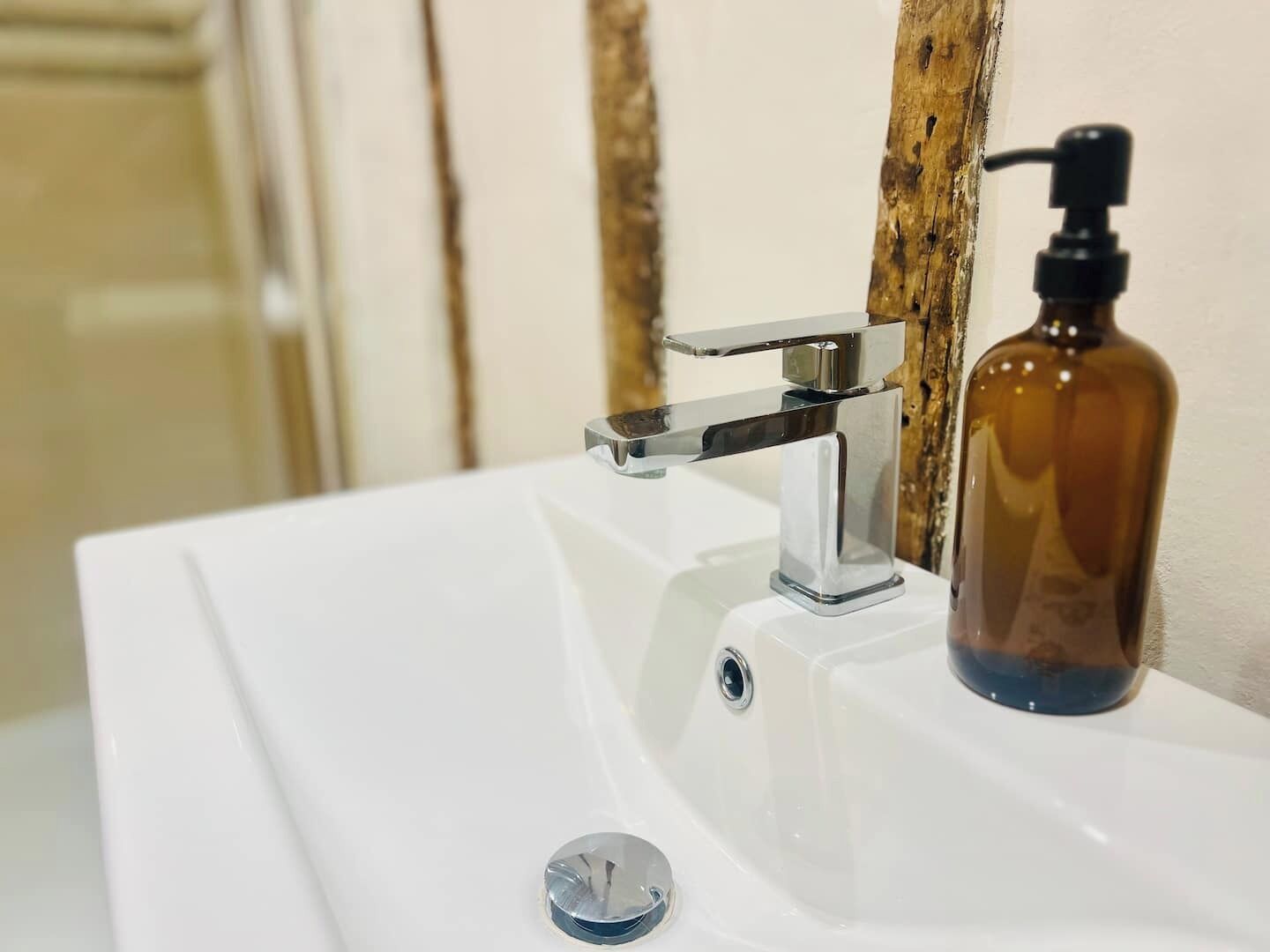Un lavabo de salle de bain avec un robinet chromé et un distributeur de savon.
