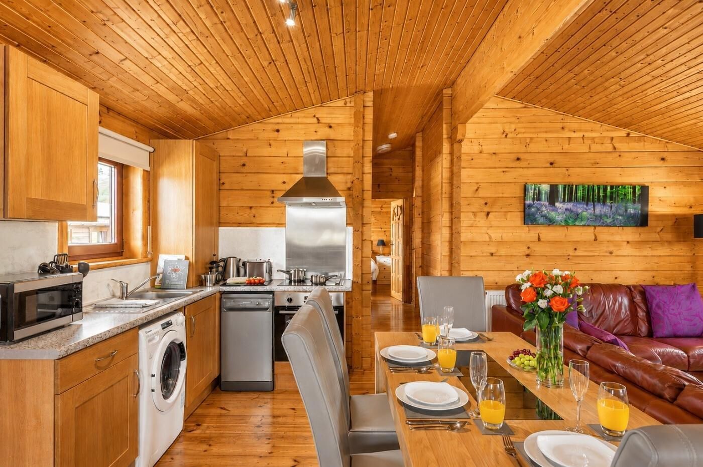A cabin interior with a kitchen, dining area, and living room.