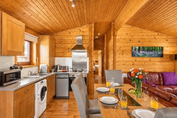 Ein Ferienhausinnenraum mit Küche, Essbereich und Wohnzimmer.