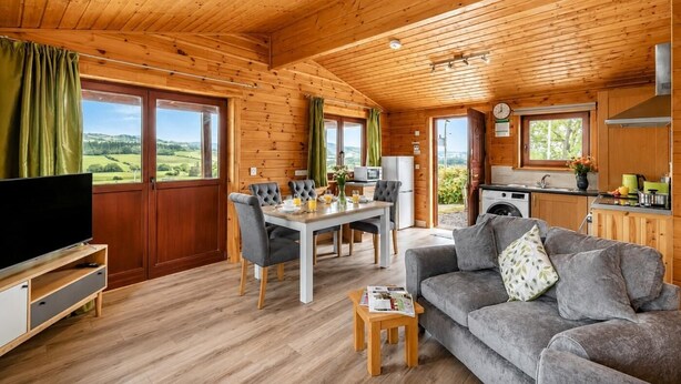 A wooden cabin interior with a dining area, kitchen, and living room. - 2 Bed in Llandinam (oc-t31974) (Llandinam)