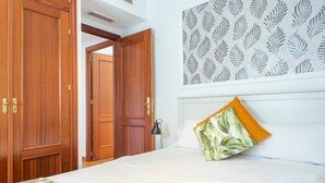 Une chambre d’hôtel comprenant un lit, une table de chevet, une lampe et une armoire.