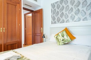 A hotel room with a bed, a nightstand, a lamp, and a wardrobe. - Stay near Feria, Madrid (Seville)