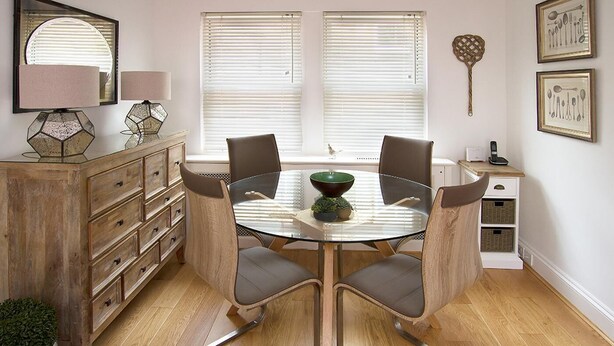 A dining area with a round glass table, four chairs, a bowl, and a cabinet with drawers. - 2 Bed in Bath (oc-bhr50) (Bath)