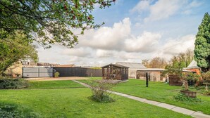 A well-maintained garden with a lawn, a wooden shed, and a metal structure in the background. - 4 Bed in Bath (oc-bhr4) (Bath)