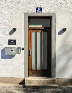 A building entrance with a door, a mailbox, and a sign indicating the address.