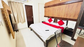 A hotel room with a bed, a desk, a chair, a wardrobe, and a door. - Townhouse Star Square Vijay Nagar (Indore)