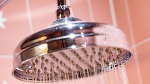 Een douchekop waar water uit stroomt.