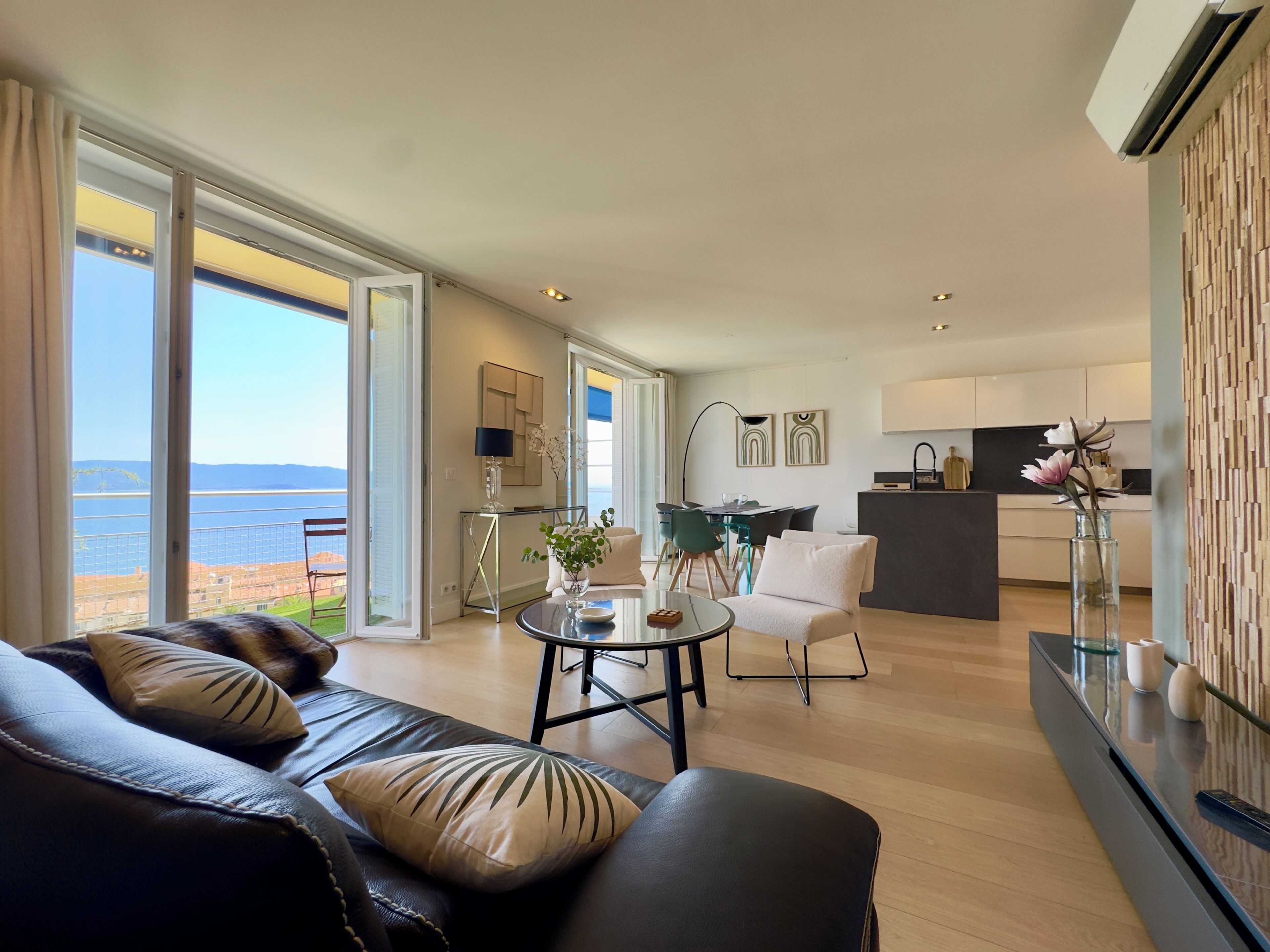 Een moderne woonkamer met een bank, een eethoek en een keuken.