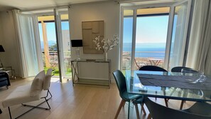 Ein modernes Wohnzimmer mit einem Glastisch, einer Couch und Blick auf den Ozean.