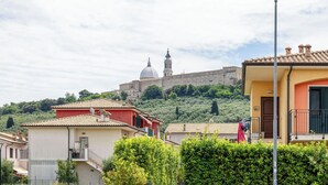 Un quartier résidentiel avec des maisons, un lampadaire et un grand bâtiment surmonté d’un dôme, visible au loin.