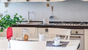 Une cuisine équipée d’une cuisinière à gaz, d’un évier et d’un pare-feu.