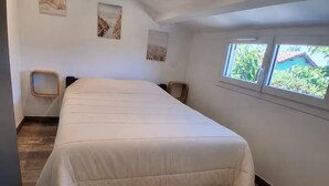 Makuuhuoneessa on suuri sänky, puulattia, pieni työpöytä ja ikkuna, josta avautuu näkymä vehreään maisemaan.