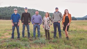 A group of people standing in an open field with a forested hill in the background. - Gorgeous 2-bedroom house with AC in charming Williams (Williams)