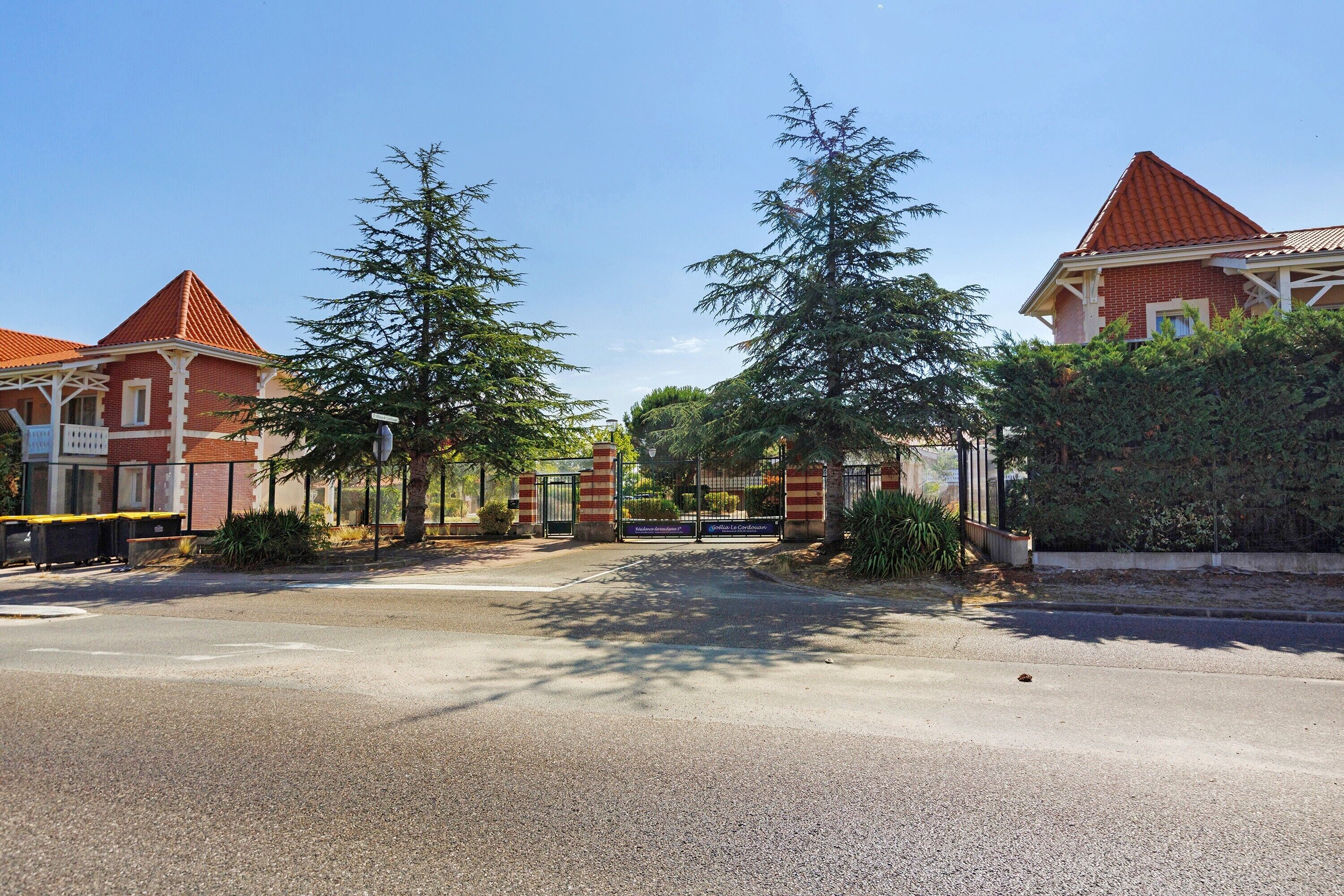 Een woonstraat met huizen, een poort en bomen.