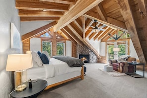 A cozy loft bedroom with a bed, a fireplace, a sofa, and a dining table. - Breckenridge Outdoor Oasis | Pool Table + Hot Tub (Breckenridge)