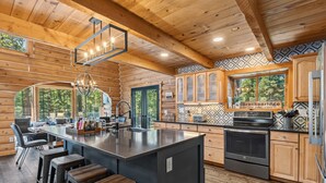 L’intérieur d’une cabane en rondins comprend une cuisine, un coin bar et un espace repas.