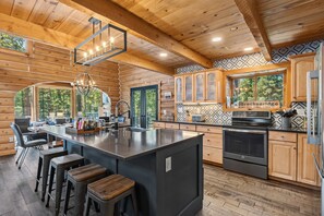 A log cabin interior with a kitchen, bar area, and dining space. - Breckenridge Outdoor Oasis | Pool Table + Hot Tub (Breckenridge)
