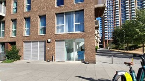 Een meerlaags woongebouw met een bakstenen gevel, grote ramen en een fiets ervoor geparkeerd.