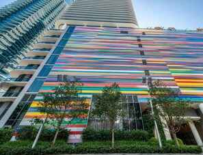 Un immeuble de grande hauteur doté d’une façade à rayures distinctives et de nombreux balcons.