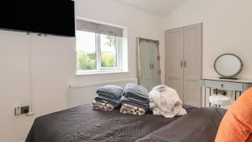 A bedroom with a bed, a window, a wardrobe, and a mirror.